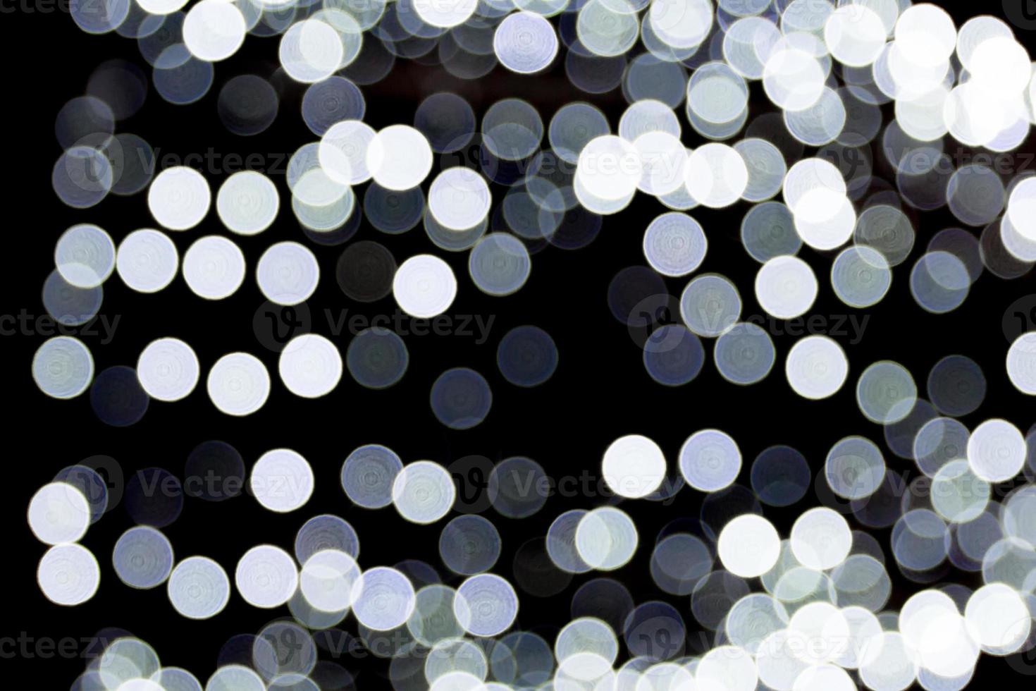 Abstract bokeh of white city lights on black background. defocused and blurred many round light photo