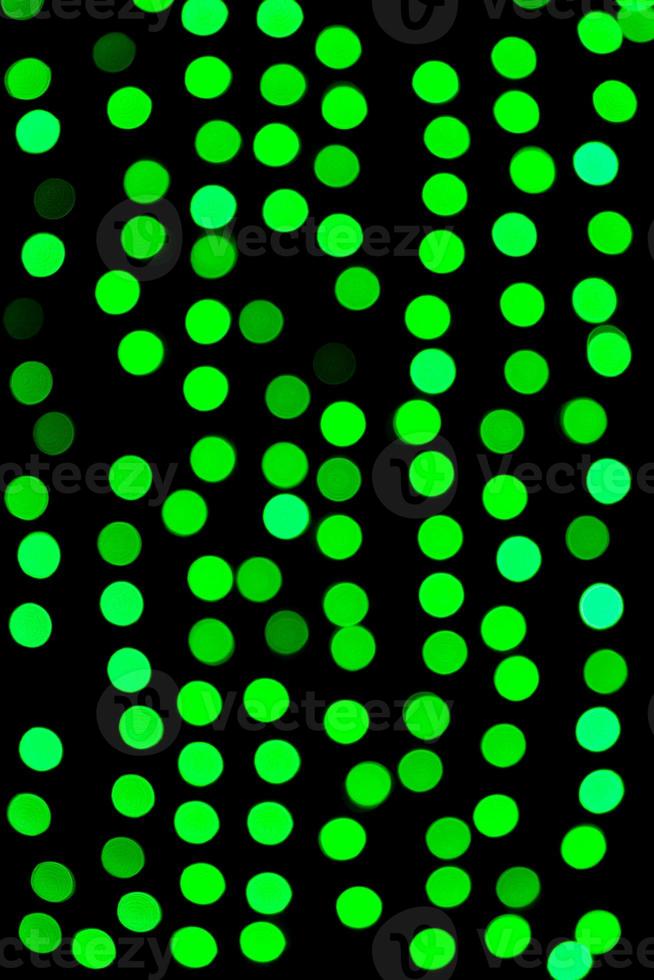 Unfocused abstract green bokeh on black background. defocused and blurred many round light photo