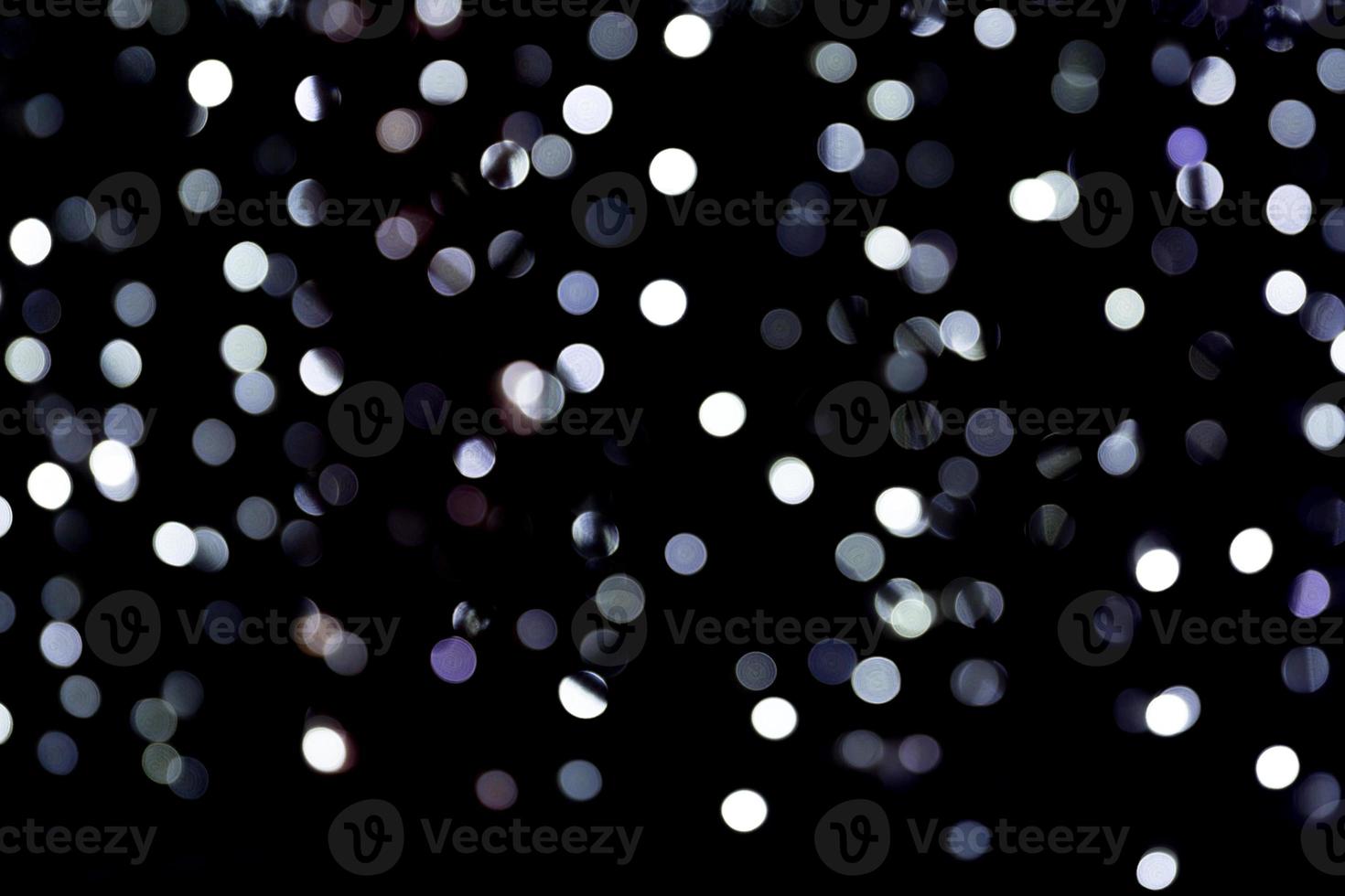 Abstract bokeh of white city lights on black background. defocused and blurred many round light photo