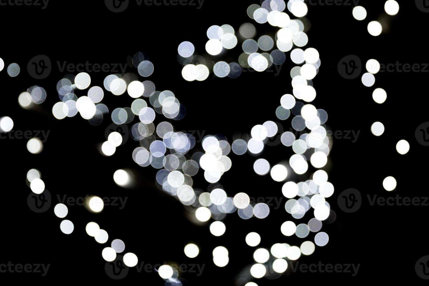 Bokeh blanco abstracto desenfocado sobre fondo negro. desenfocado y borroso muchas luces redondas foto