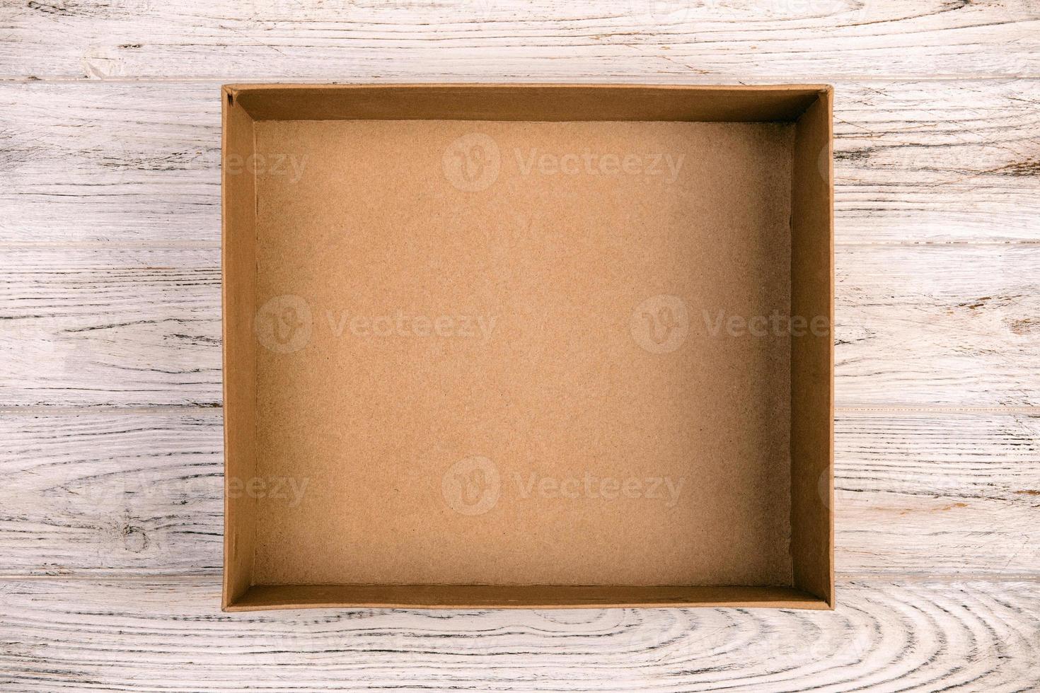 Empty Cardboard box on a white wooden background vintage, toned top view photo