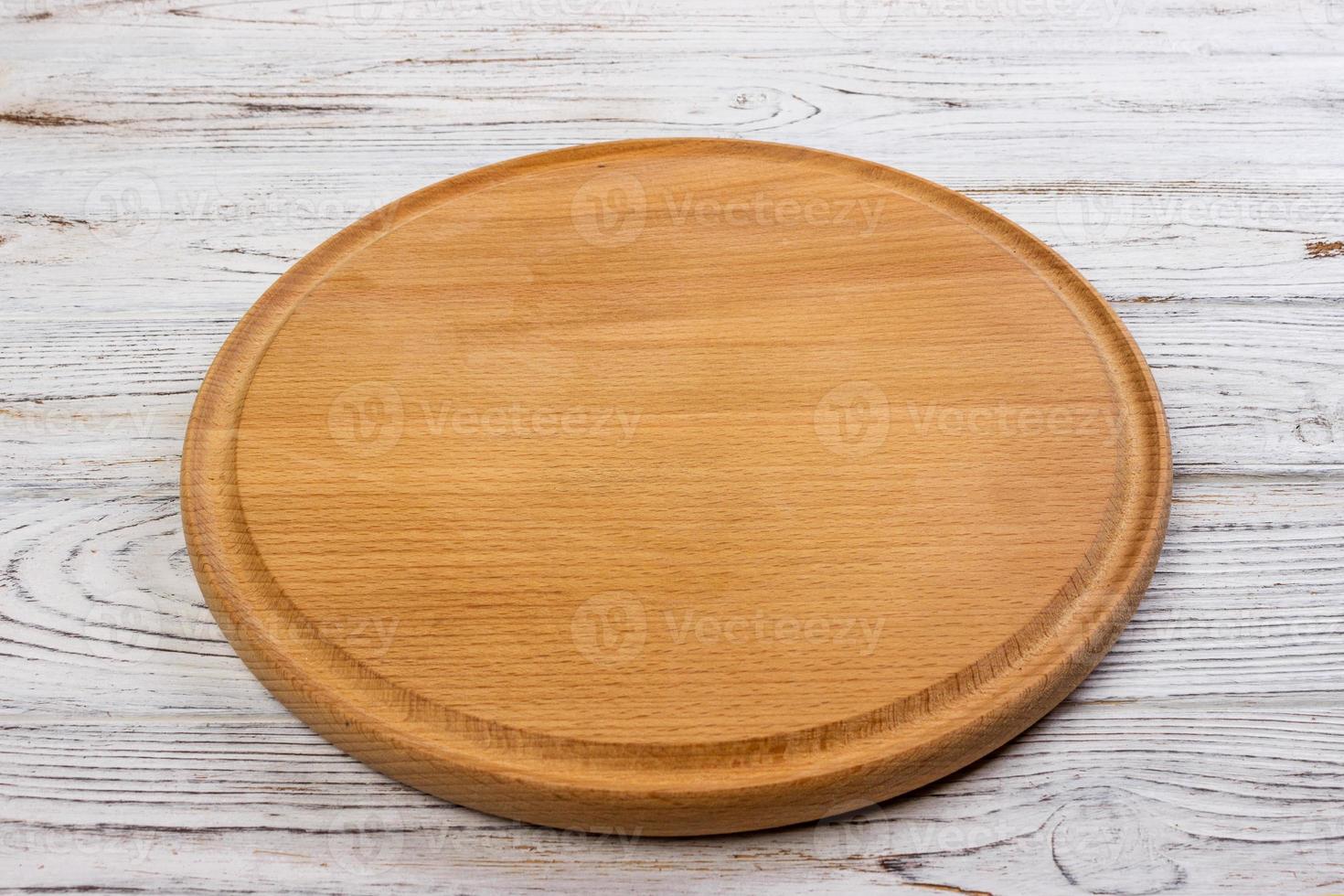 Wooden round empty board for pizza on wood table background, top view. Mockup for menu, recipe or any dish. Vertical image photo