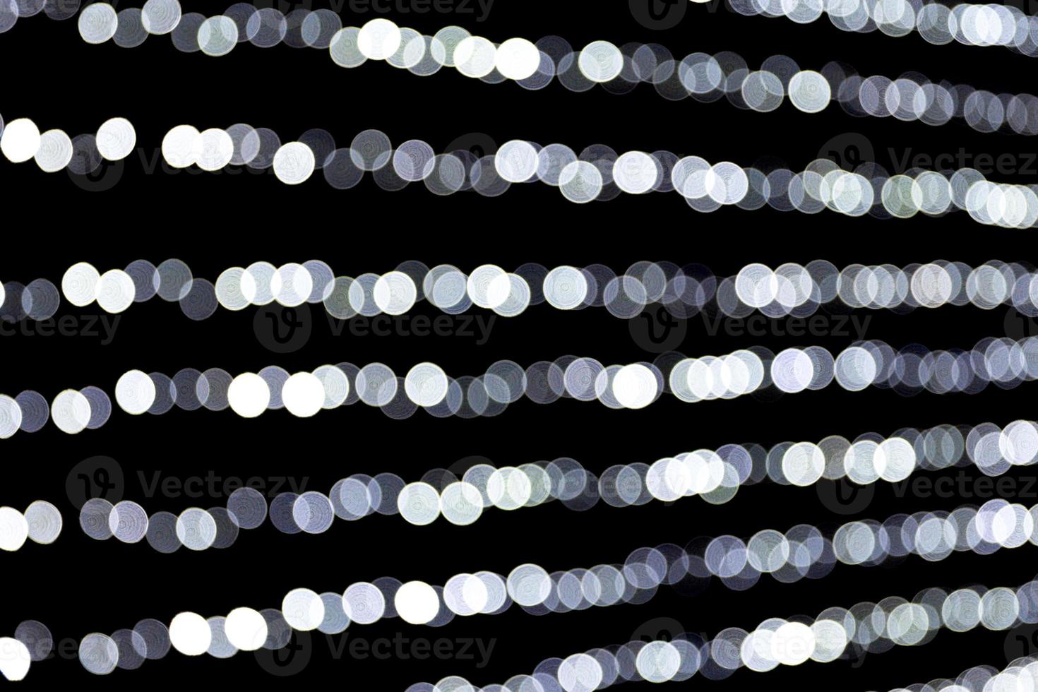 Abstract glitter sparkle bokeh defocused on black background. many round light on background photo