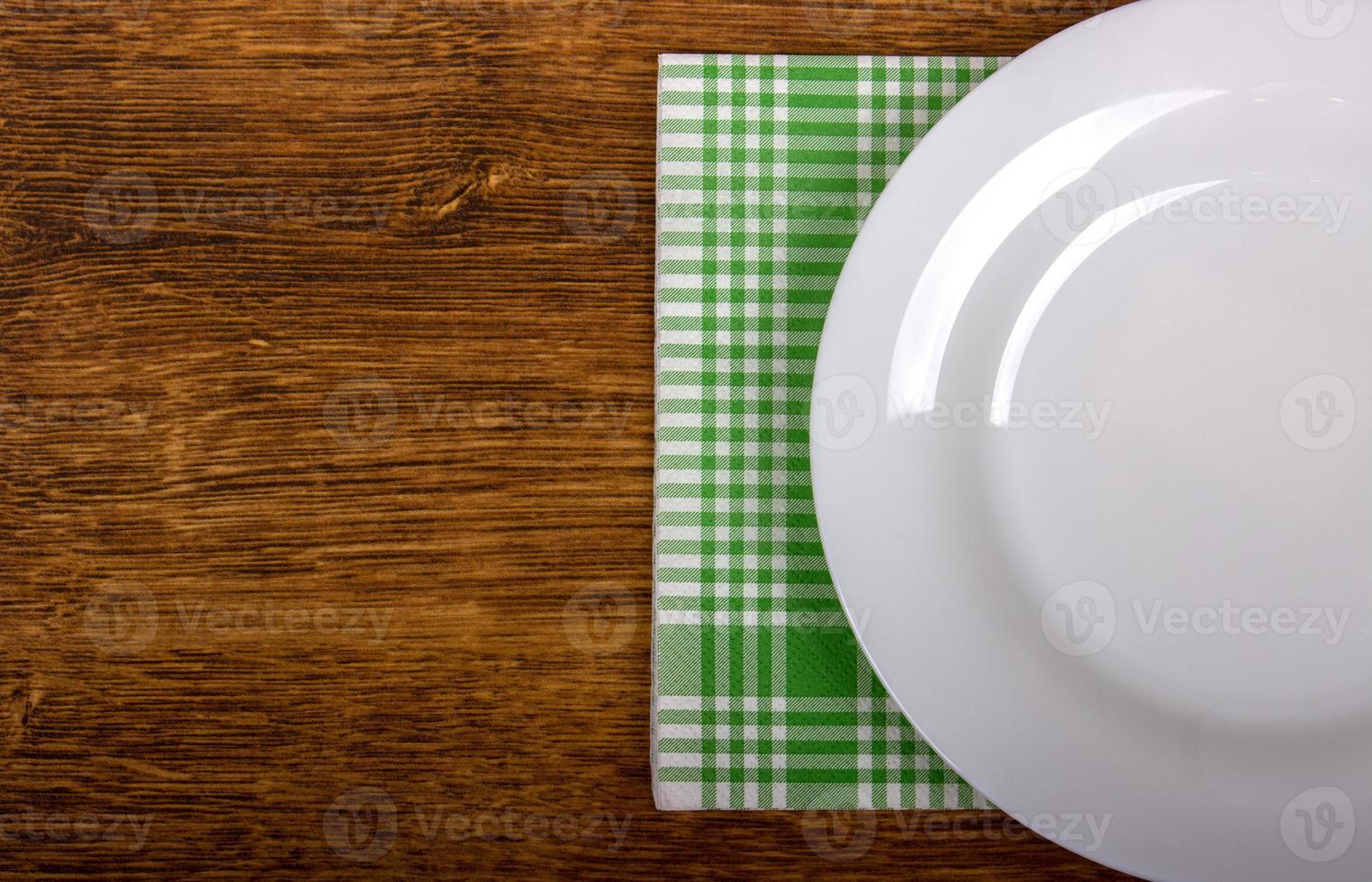 Top view of clean empty plate on wooden tabletop photo