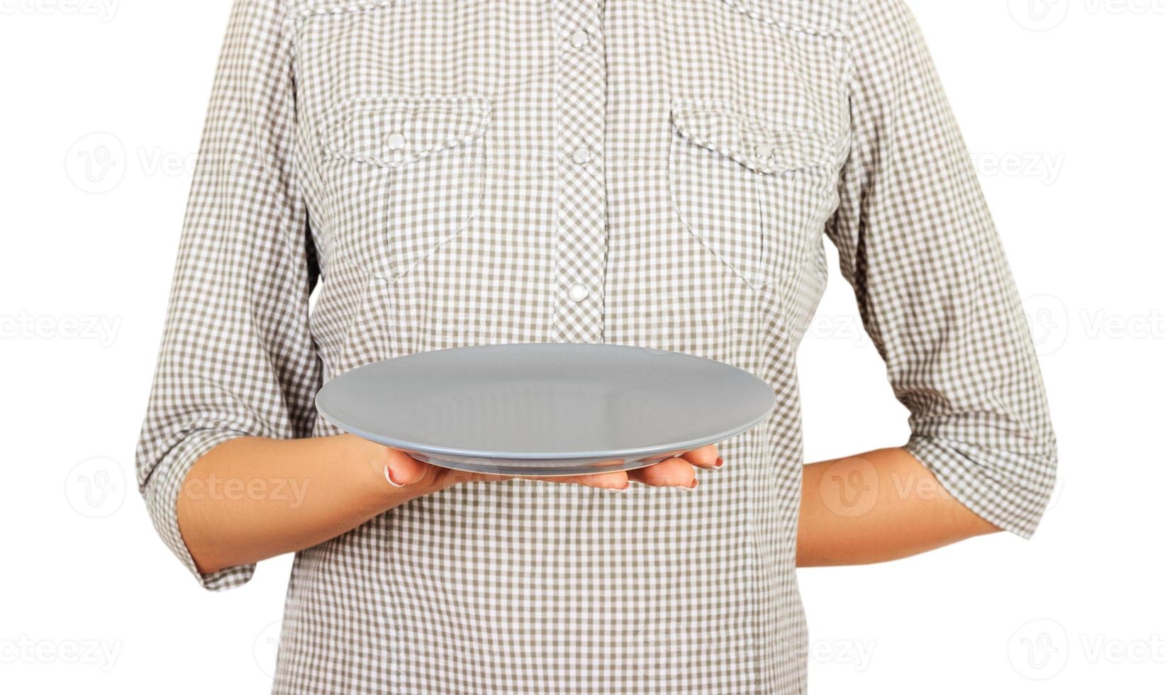 waiter girl holds an empty round matte plate with one hand. perspective view Template for your design. isolated on white background photo