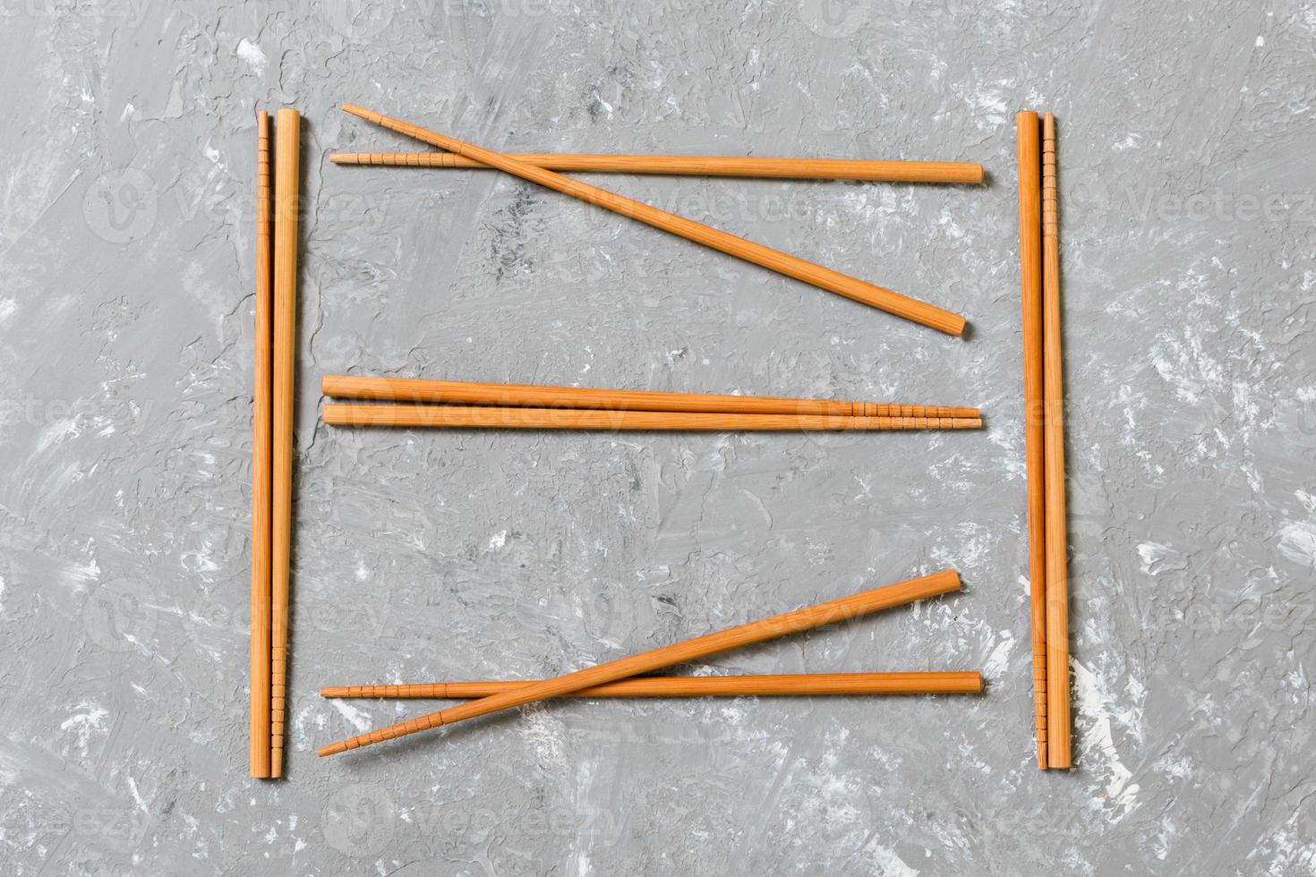 Many bamboo chopsticks on black cement stone background, top view with copy space. a lot of sushi sticks in the form of an ornament photo