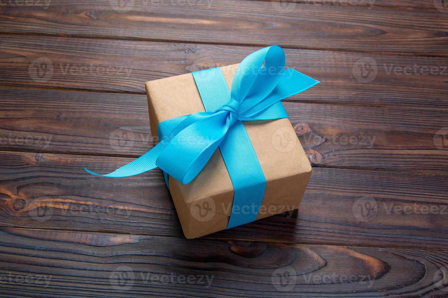 holidays gift with blue ribbon on wooden background top view photo