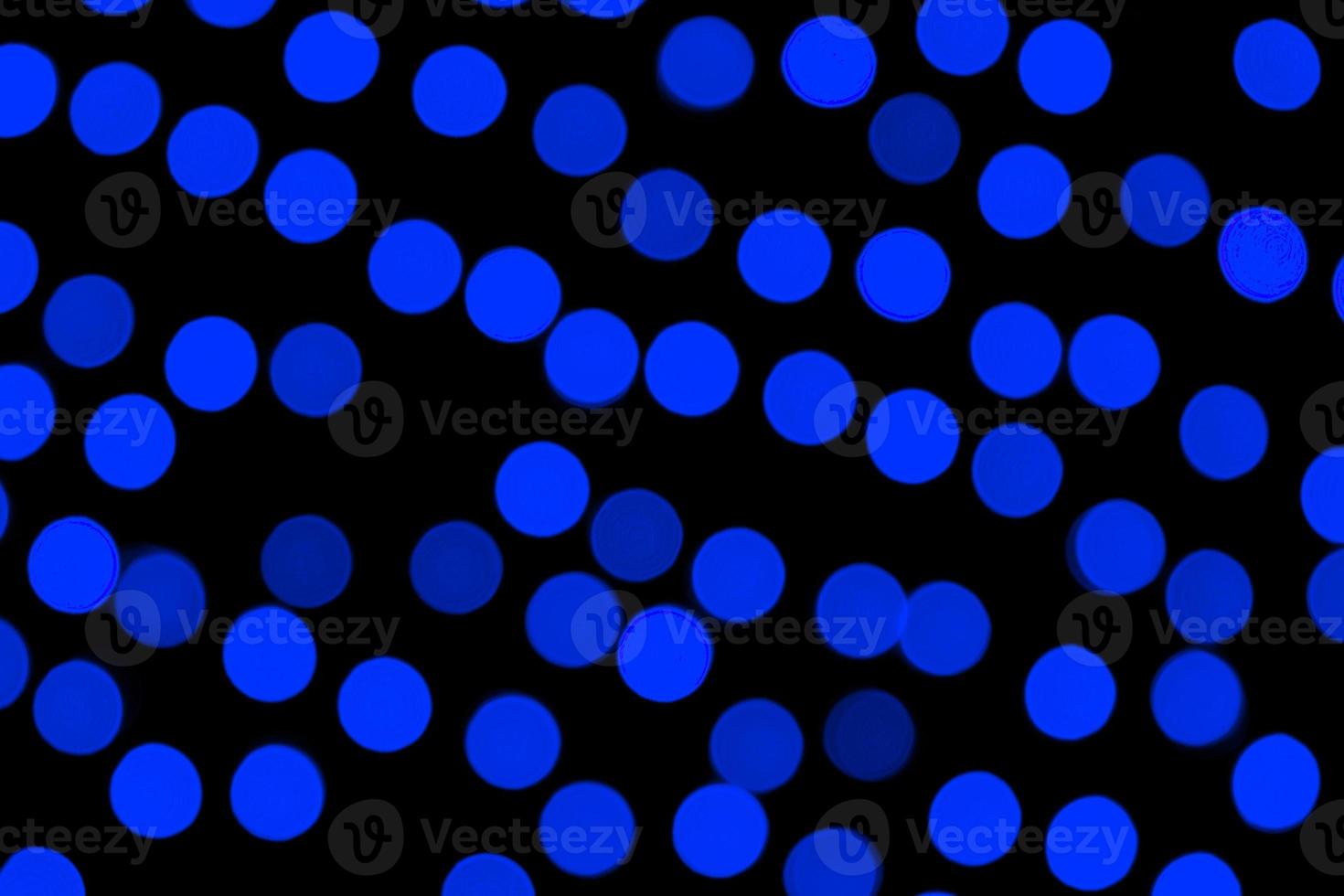 Unfocused abstract dark blue bokeh on black background. defocused and blurred many round light photo