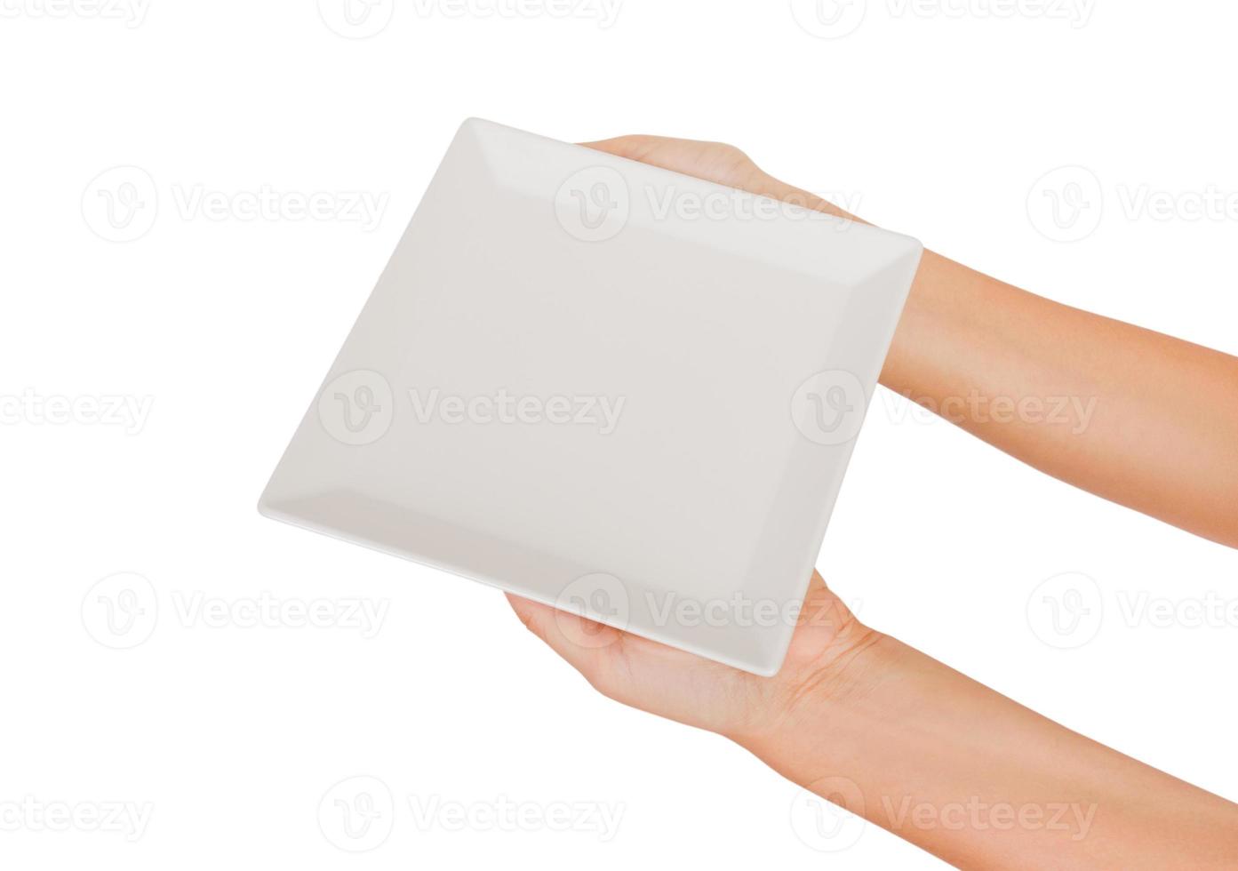 Blank white square matte plate in female hand. perspective view, isolated on white background photo