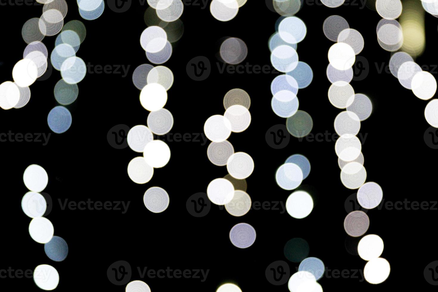 Unfocused abstract white bokeh on black background. defocused and blurred many round light photo