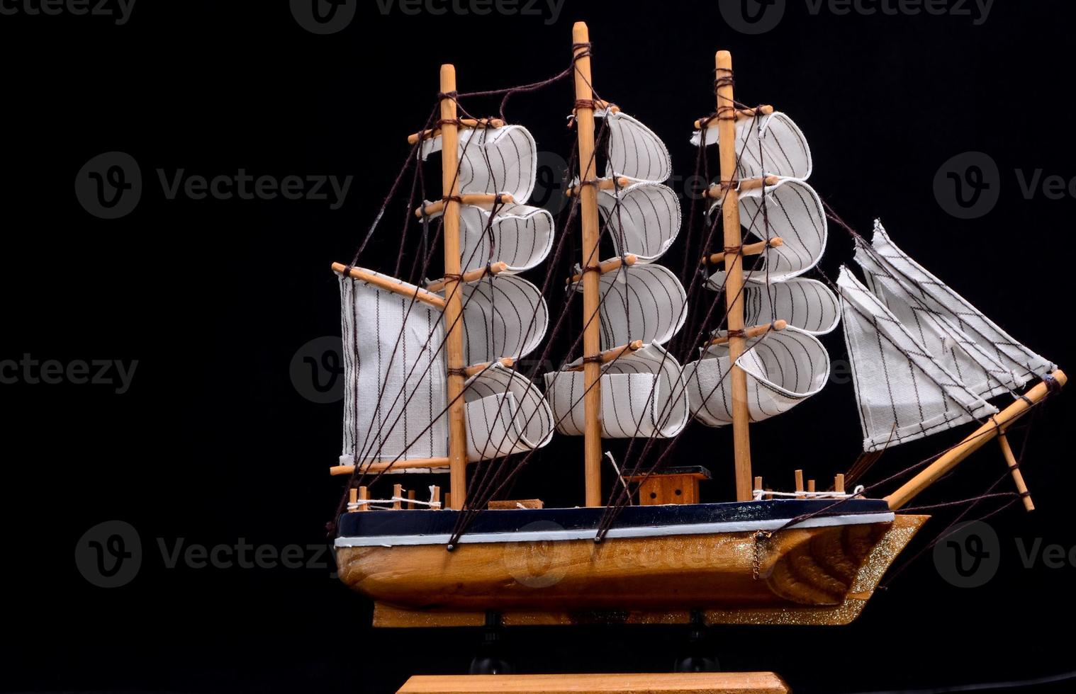 Miniature ship on black background photo