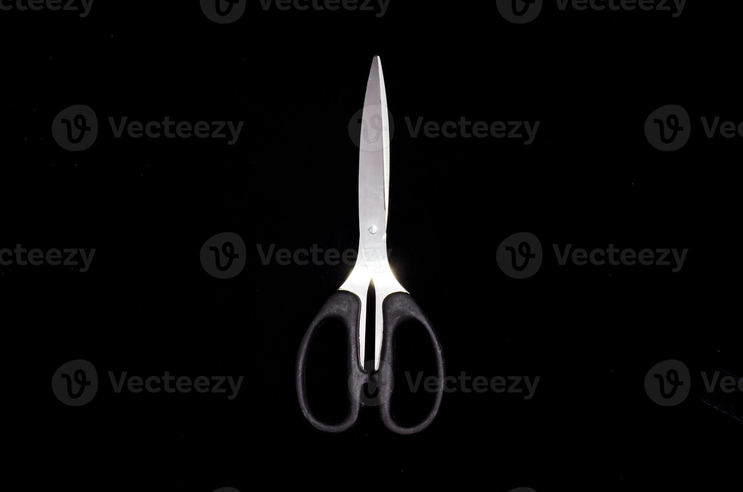 Scissors on black background photo