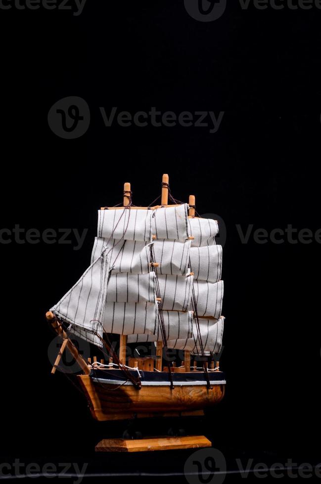 Miniature ship on black background photo