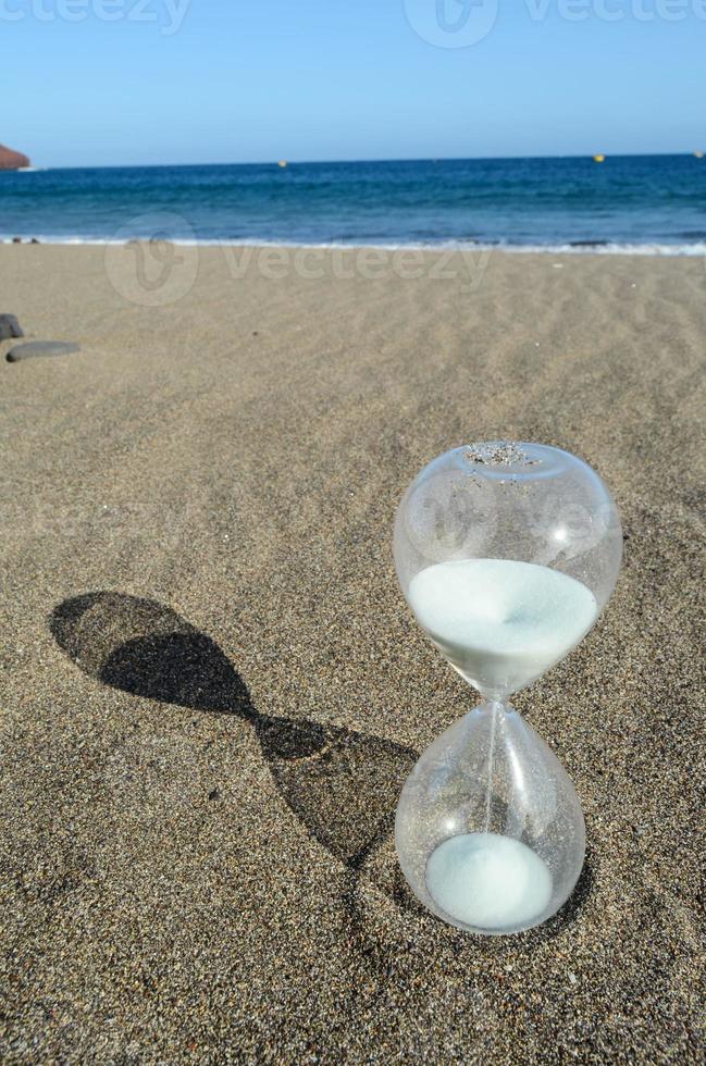 Hourglass on he sand photo