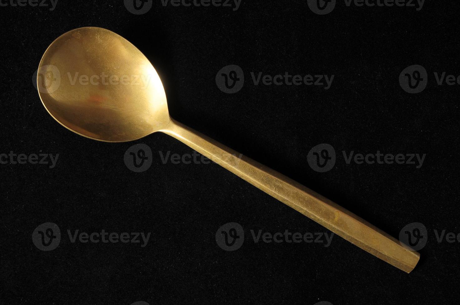 Metal spoon on dark background photo