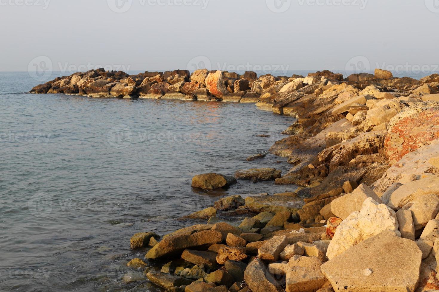 The breakwater protects the beach on the seashore from big waves. photo