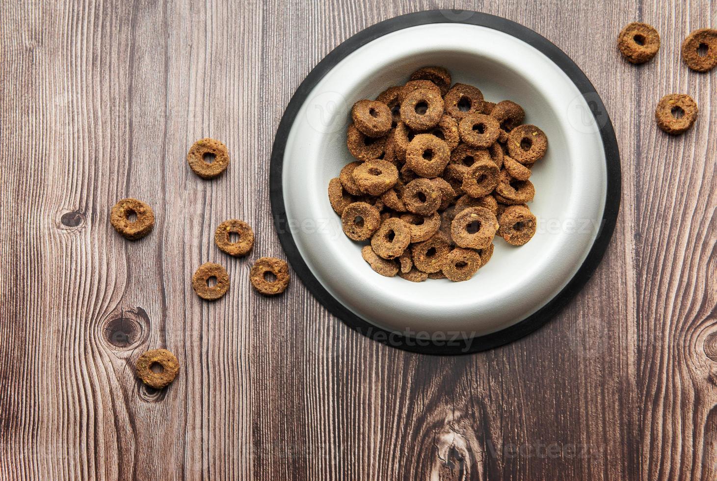 un plato de comida para perros en un piso de madera. foto