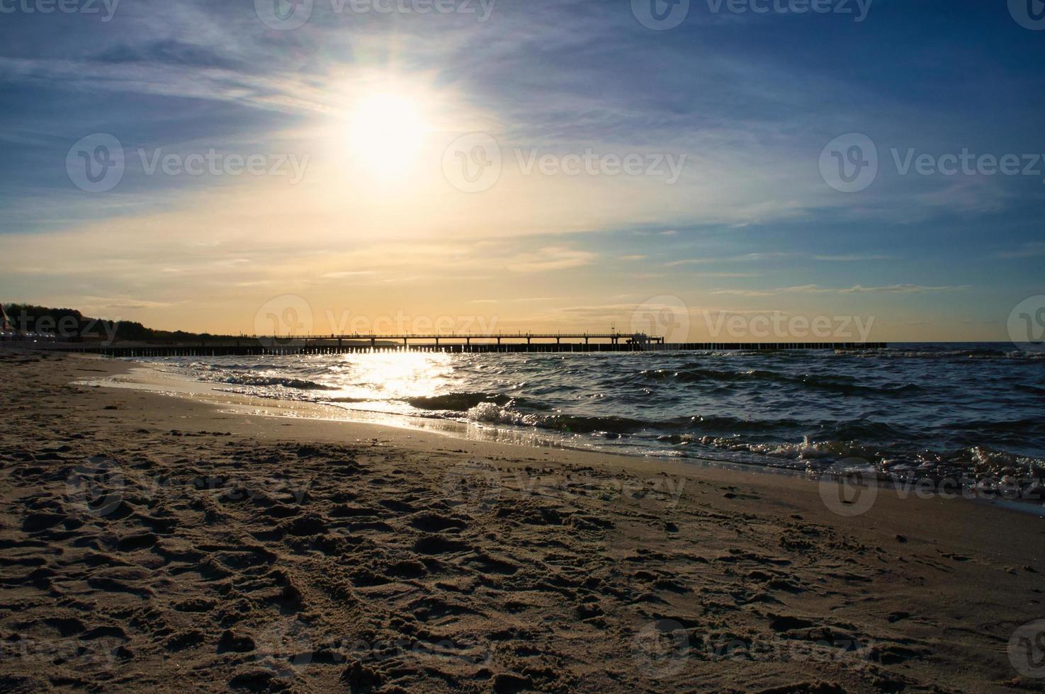 Groynes jut into the sea at sunset. The sun shines on the Baltic Sea. Landscape photo