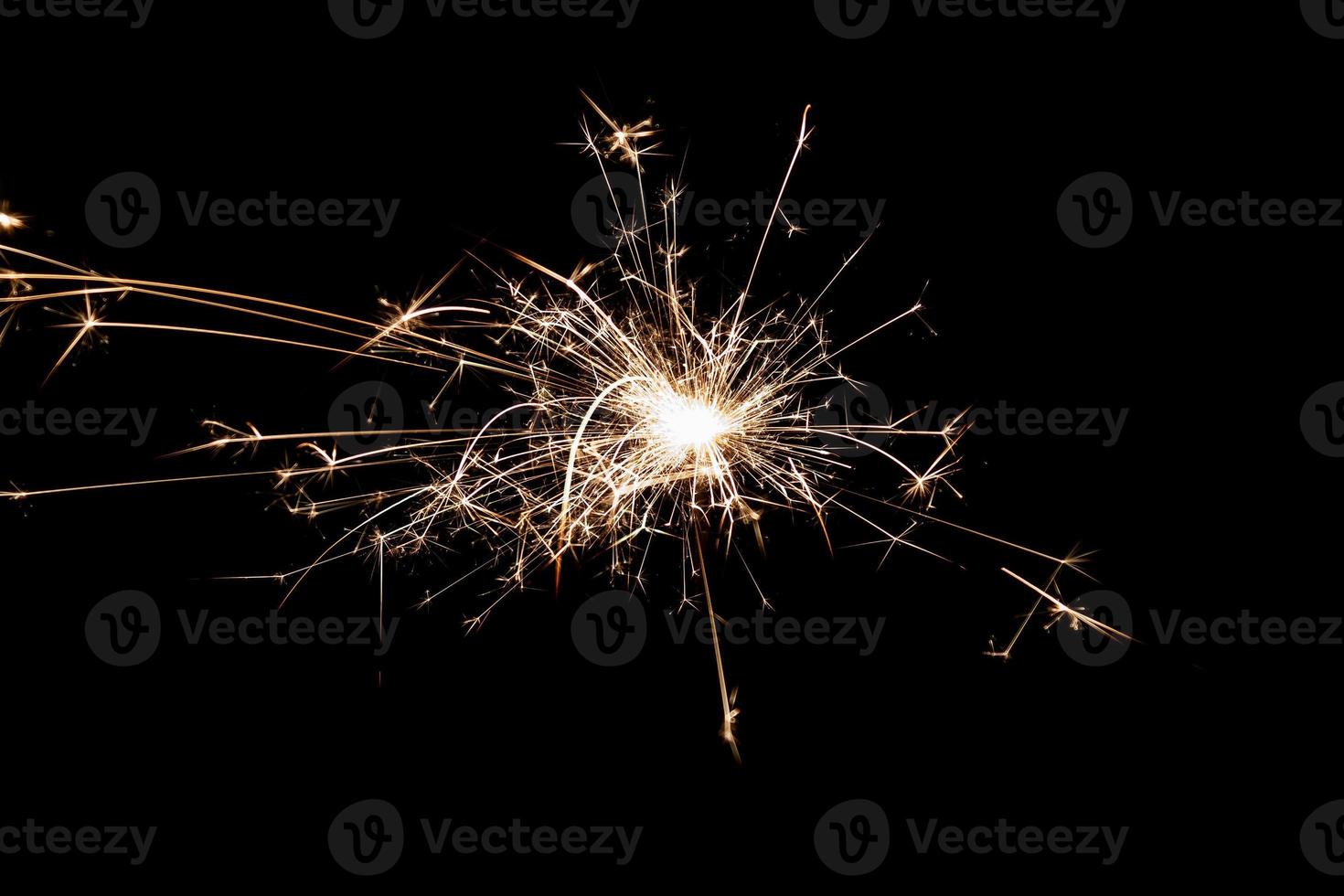 Burning sparkler isolated on black background. Fireworks theme. Light effect and texture. photo