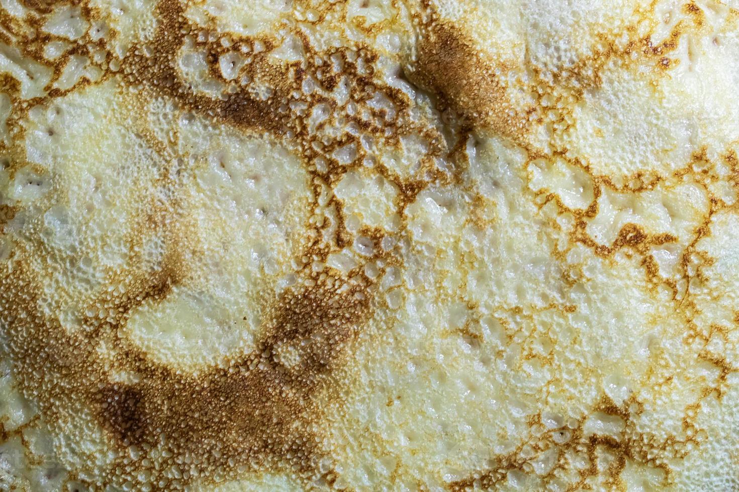 Pancake surface texture and pattern. Close-up of thin hot pancakes in a plate. Traditional rustic food. Graphic resource. photo