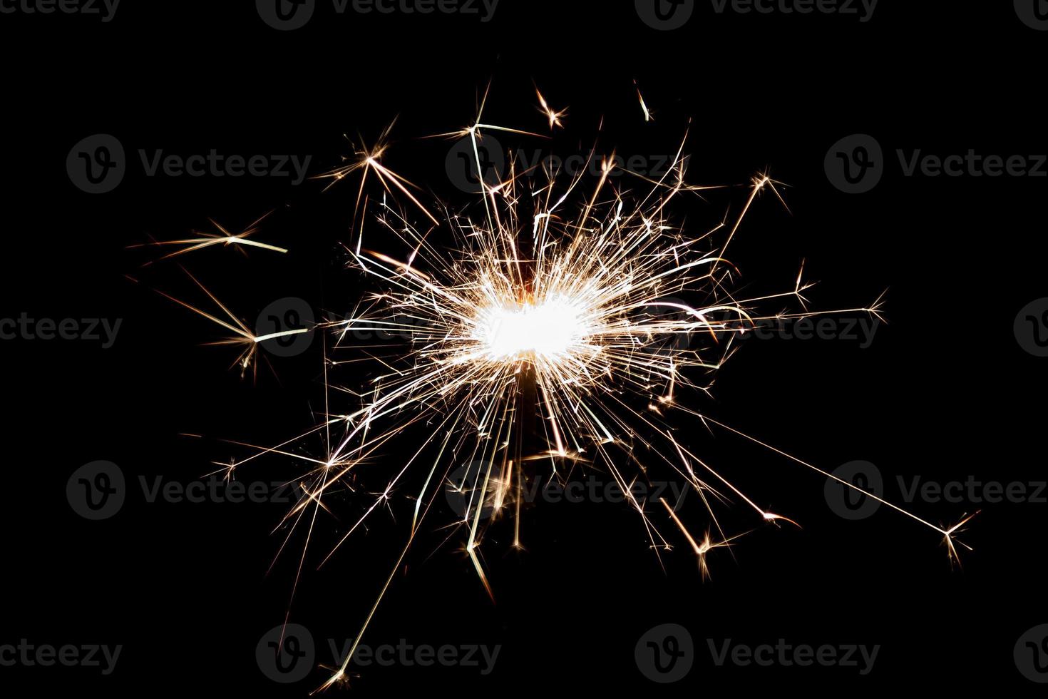 Burning sparkler isolated on black background. Fireworks theme. Light effect and texture. photo