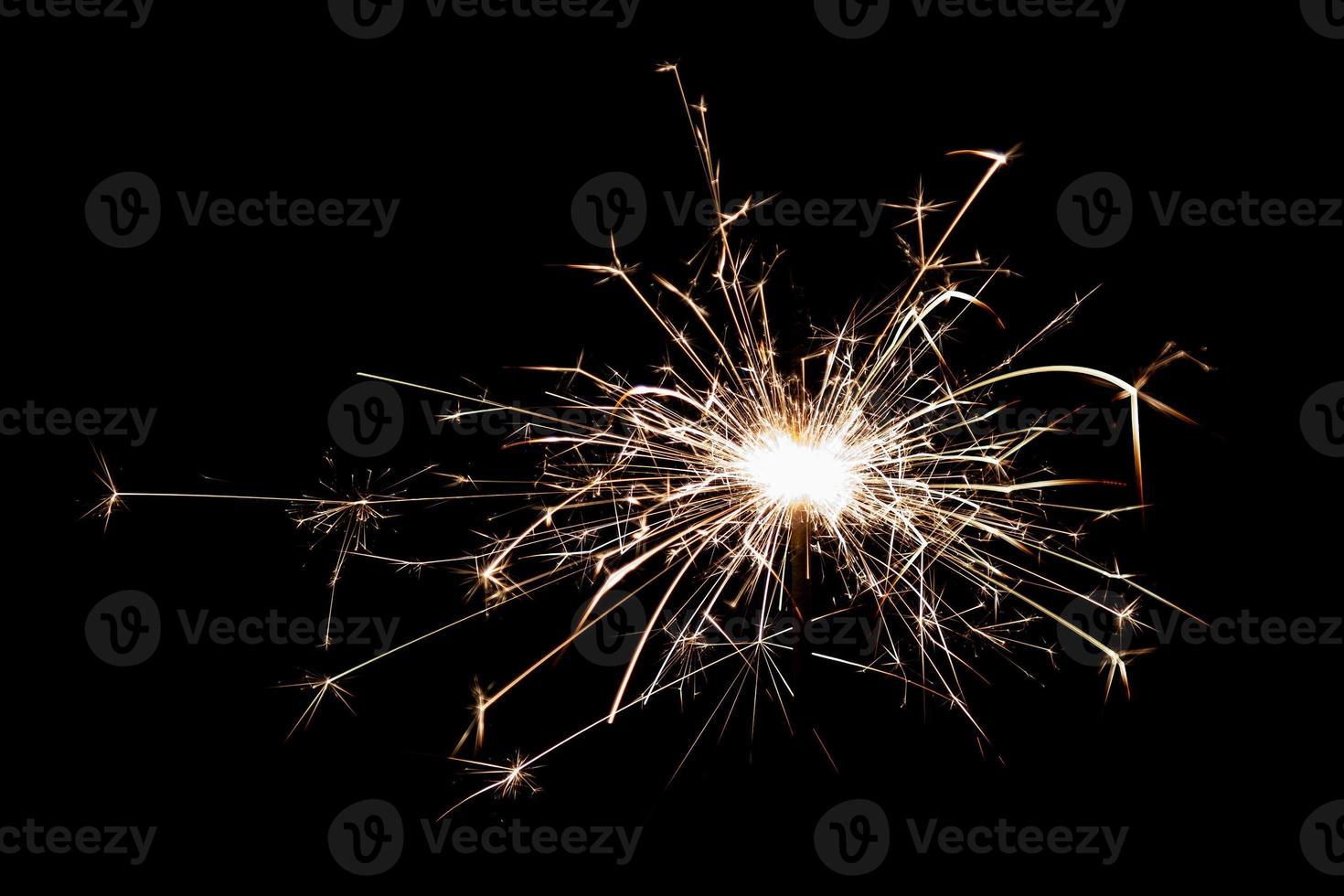 Burning sparkler isolated on black background. Fireworks theme. Light effect and texture. photo