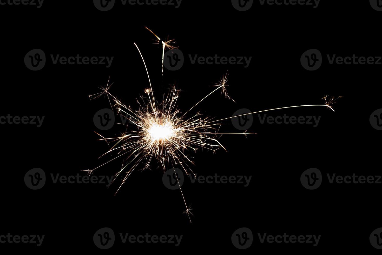 Burning sparkler isolated on black background. Fireworks theme. Light effect and texture. photo