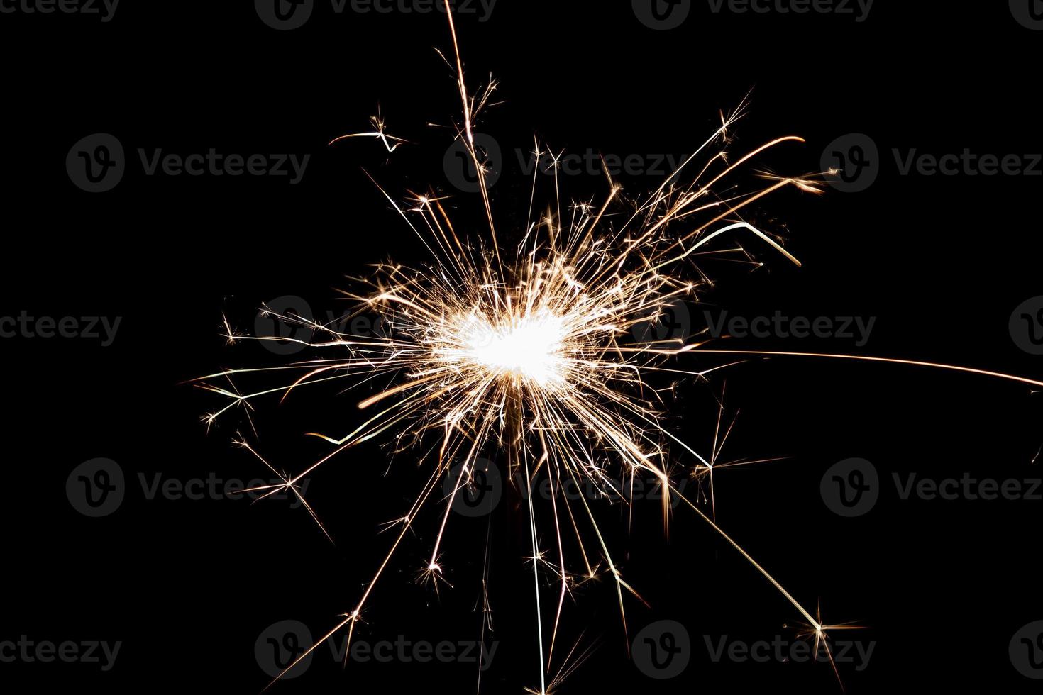 Burning sparkler isolated on black background. Fireworks theme. Light effect and texture. photo