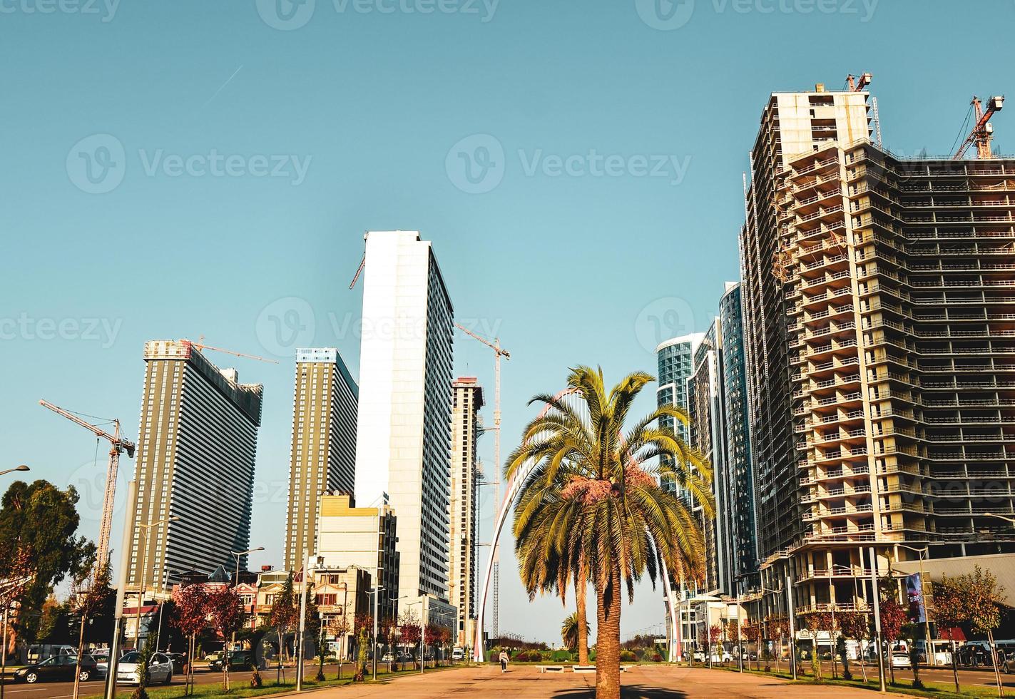 Zoom in dynamic time lapse Batumi city panorama with cars in traffic and real estate construction site with cranes in sunny day. Construction work real estate development concept photo