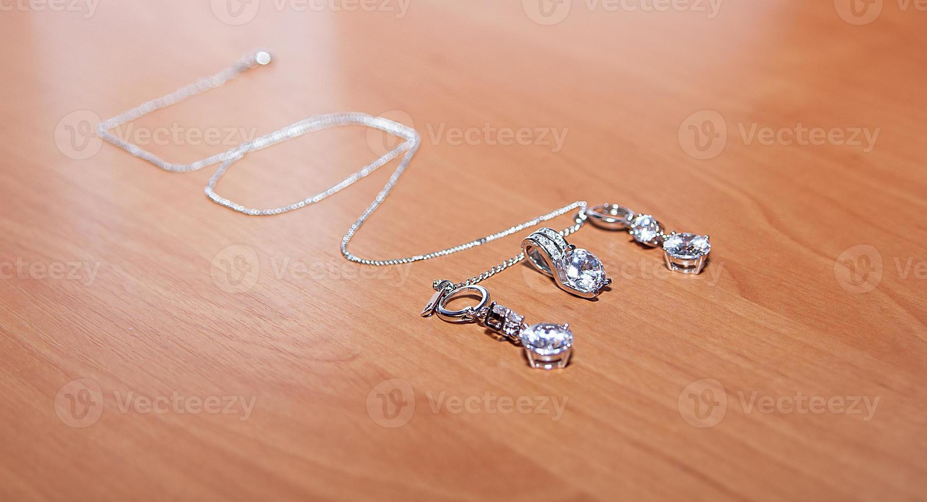 Jewelry and silver chain, on wooden desk. photo