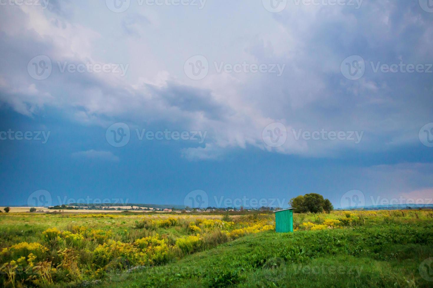 wooden toilet with a carved window in the shape of a heart, an open field photo