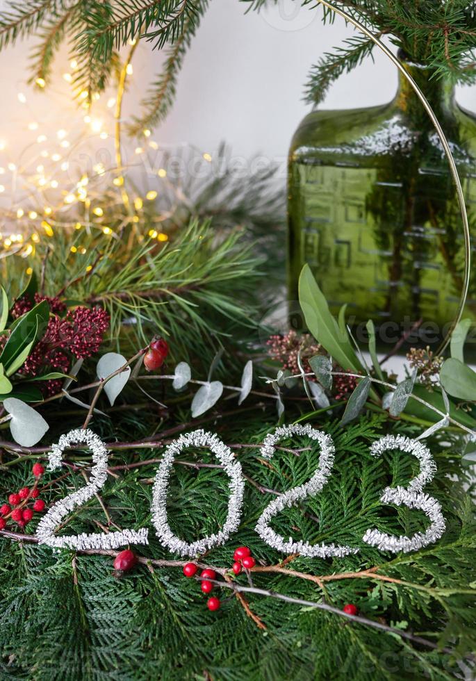 2023 new year green background from live leaves and branches. Seasonal packaging and New Year's paraphernalia. New Year's composition, a ready-made opening. photo