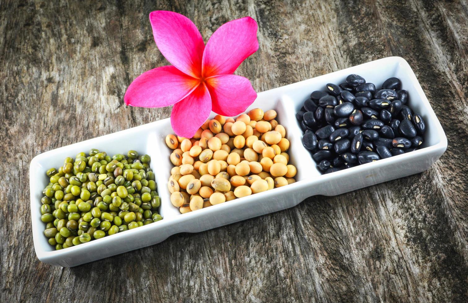 Semillas de cereales integrales Varias lentejas con frijol mungo, frijol negro y mezcla de cereales de soja en taza blanca foto