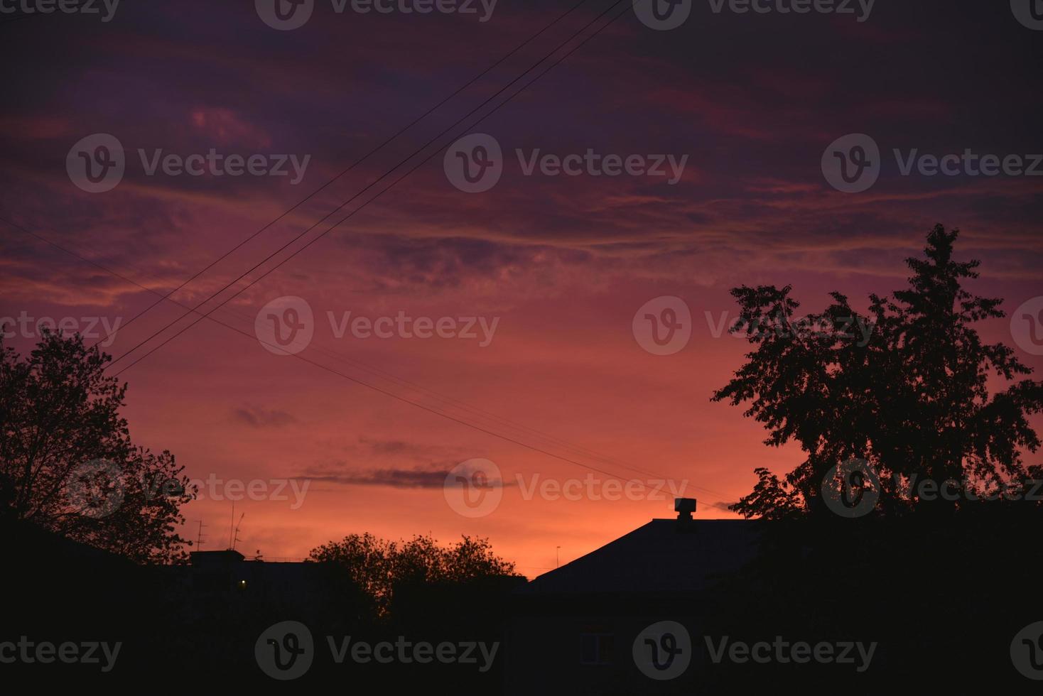 Pink bright sunset and roofs of houses in the city. Sunset evening in the city. photo