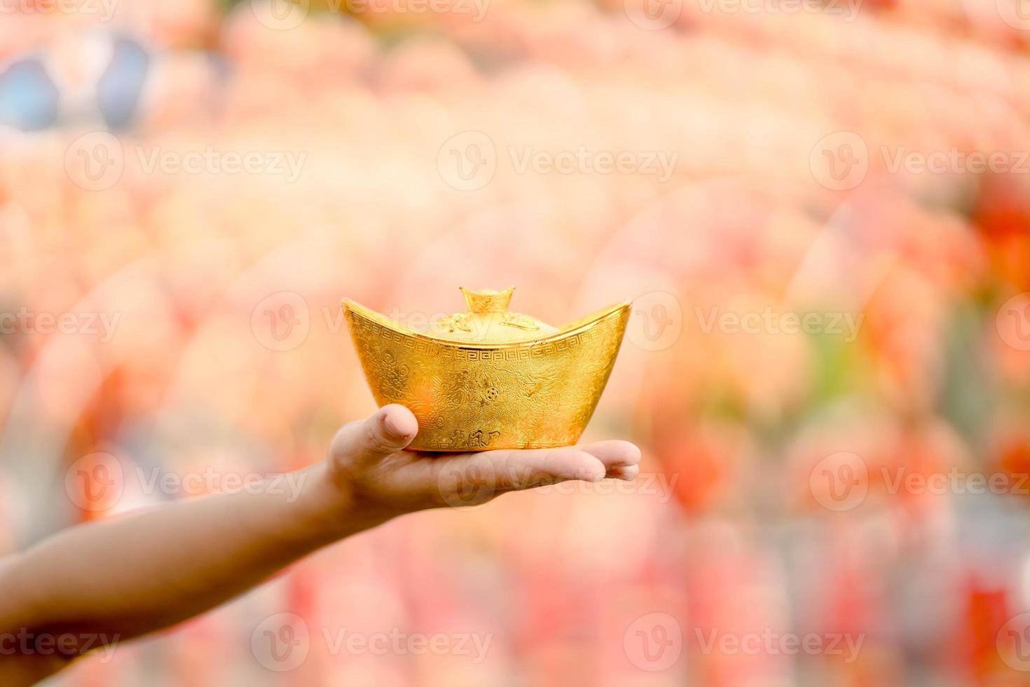 Young Asian woman wearing traditional cheongsam qipao dress holding ancient gold money in Chinese Buddhist temple. Celebrate Chinese lunar new year, festive season holiday.  Focus ancient gold money photo
