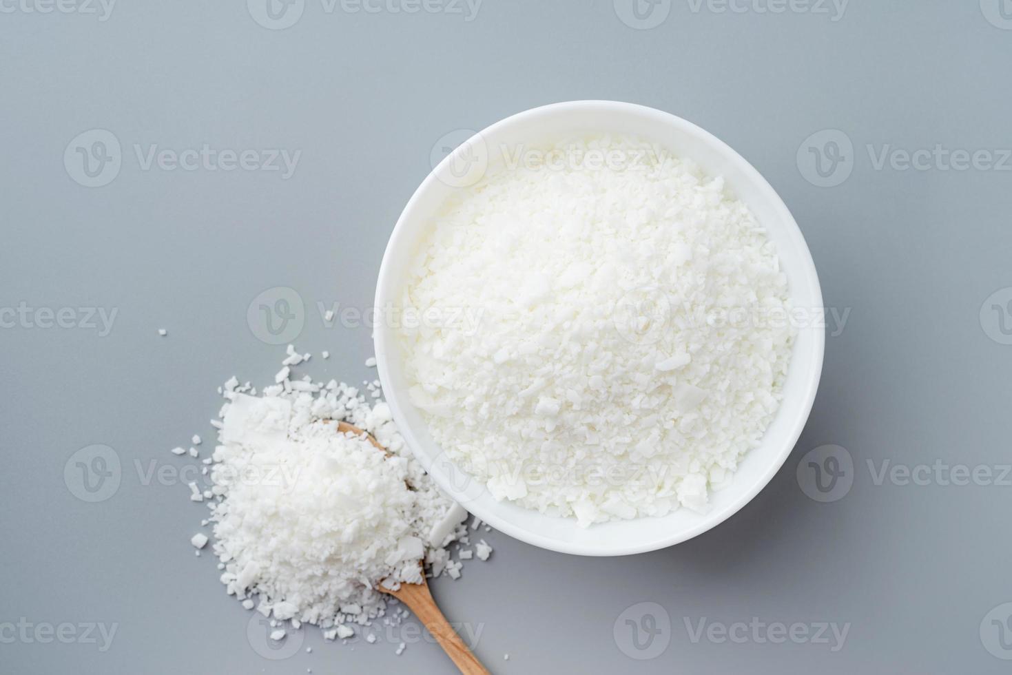 Close up of white soy wax in the bowl for candle making on gray background photo