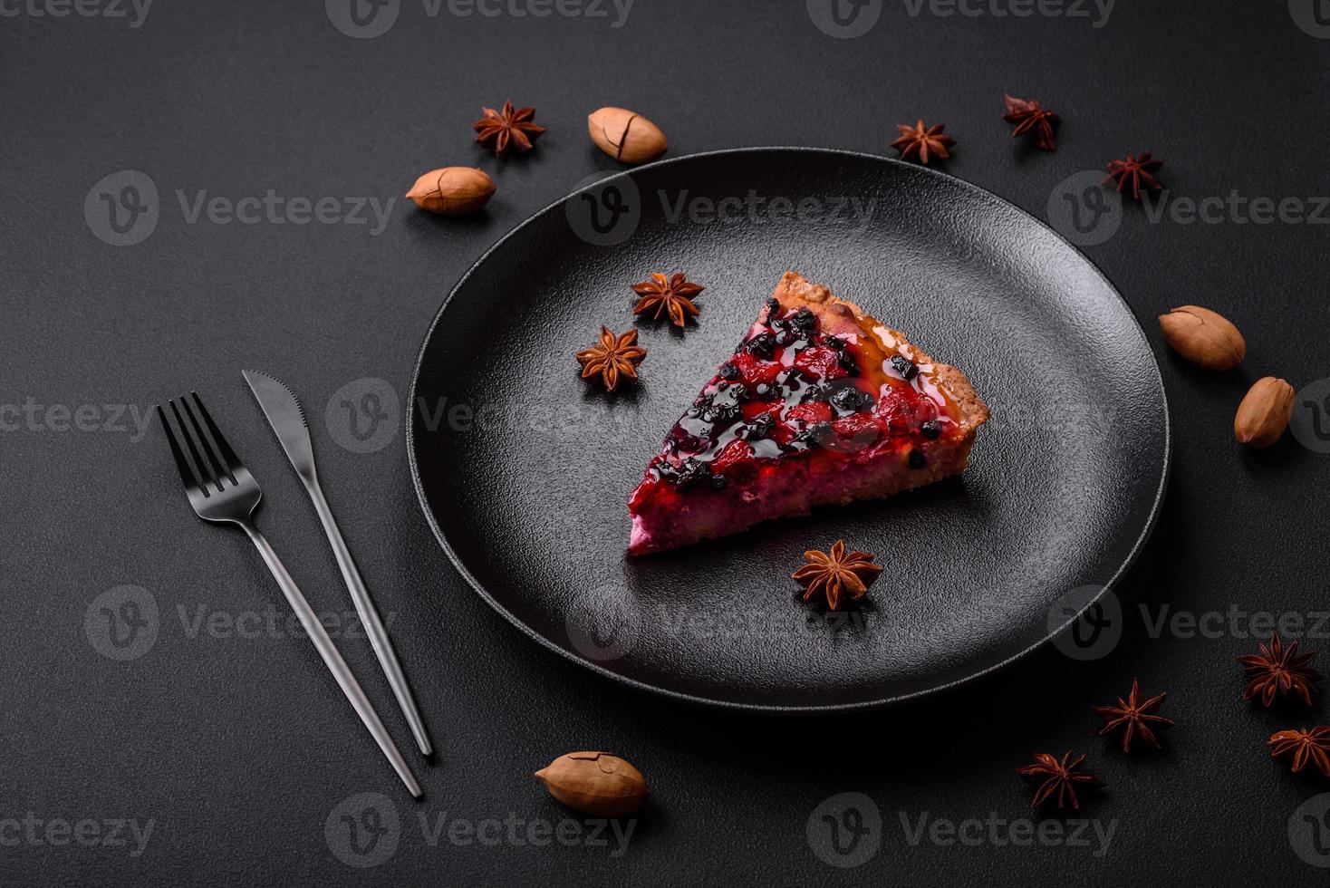 Delicious fresh pie with raspberries and other berries and cheese on a dark plate photo