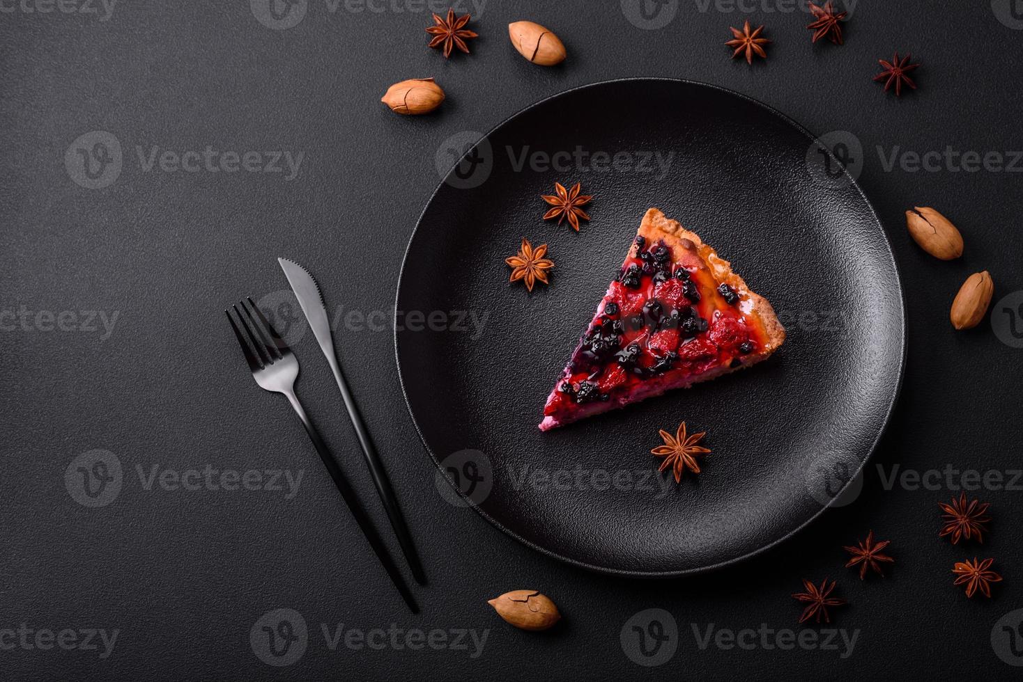 Delicious fresh pie with raspberries and other berries and cheese on a dark plate photo