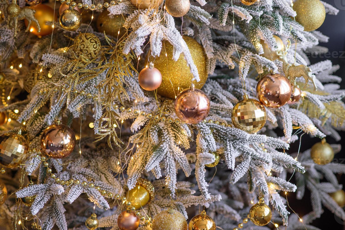 hermoso árbol de navidad con guirnaldas, pelotas y juguetes foto