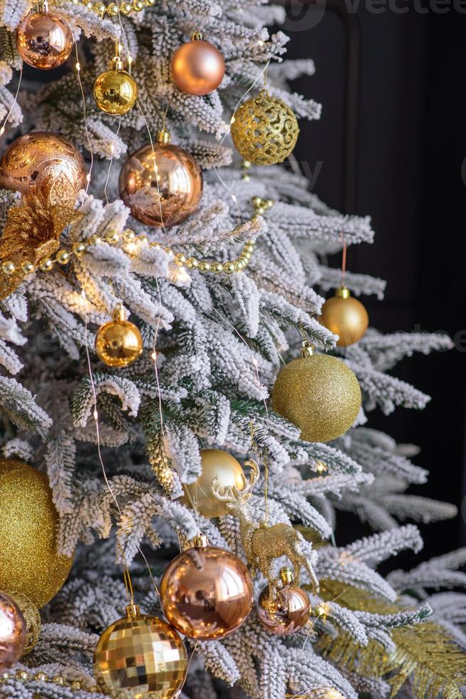 hermoso árbol de navidad con guirnaldas, pelotas y juguetes foto