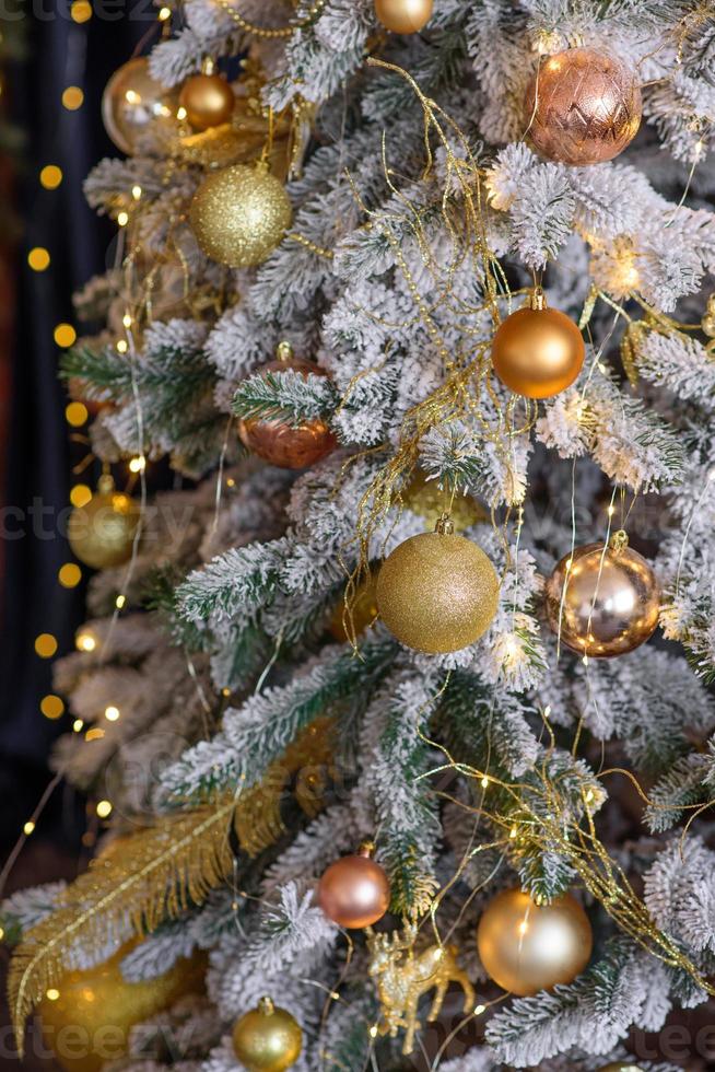 hermoso árbol de navidad con guirnaldas, pelotas y juguetes foto