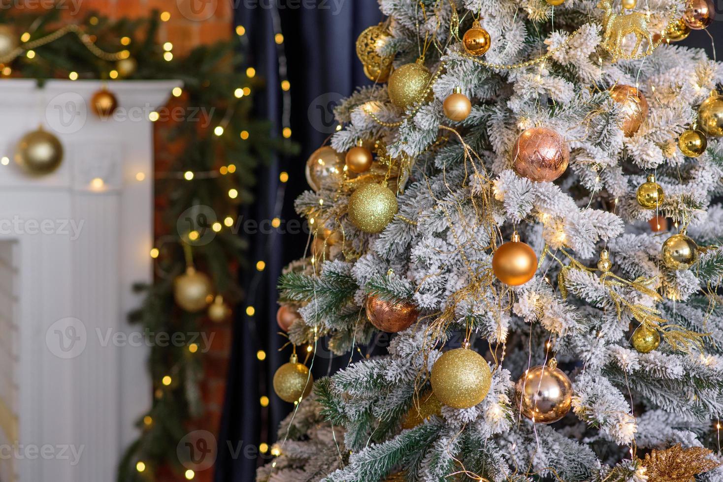 hermoso árbol de navidad con guirnaldas, pelotas y juguetes foto