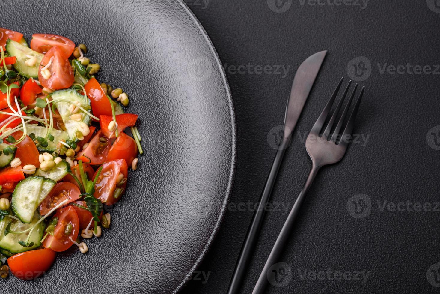 Delicious juicy fresh salad of tomatoes, peppers, cucumber, microgreens and sprouted mung bean photo