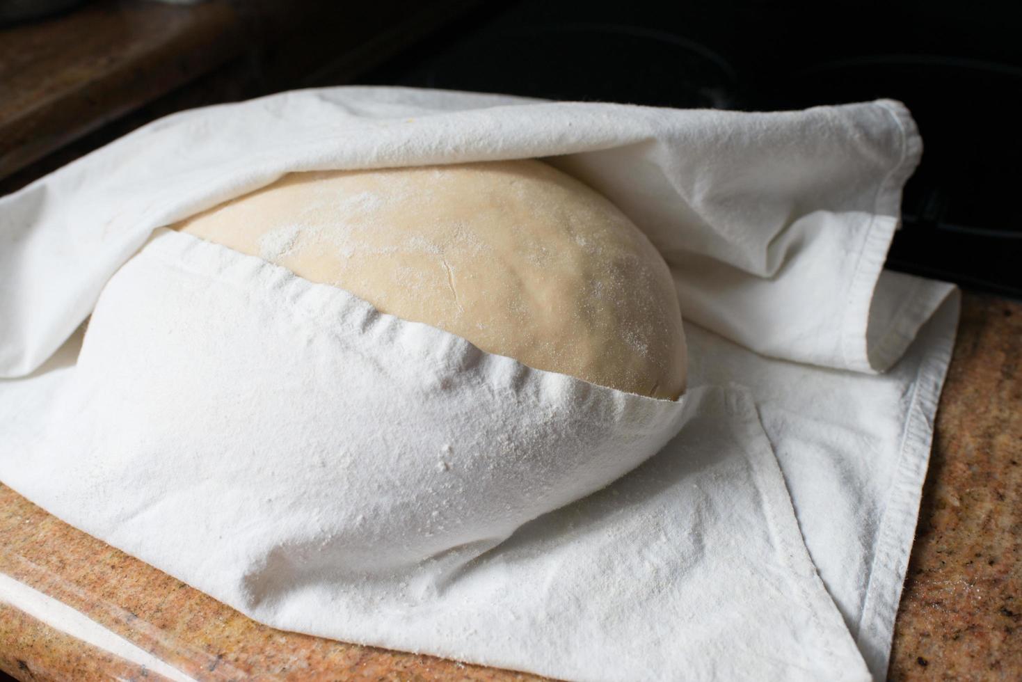 Yeast dought with a table cloth waiting to rise photo