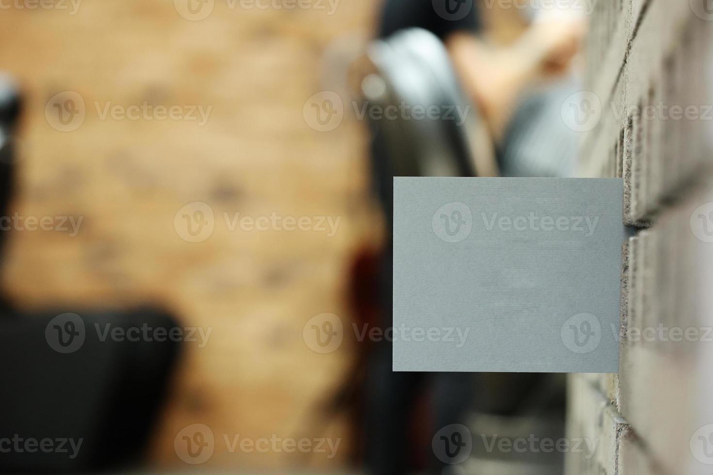 grey postcard or bossiness card with mock up on stylish barbershop or beauty salon background. blurred barber man is cutting and shaving the beard o client. photo