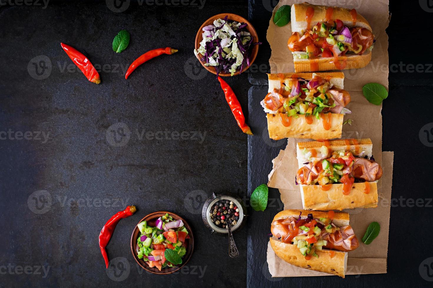 hot dog - sándwich con salsa mexicana sobre fondo oscuro. vista superior foto