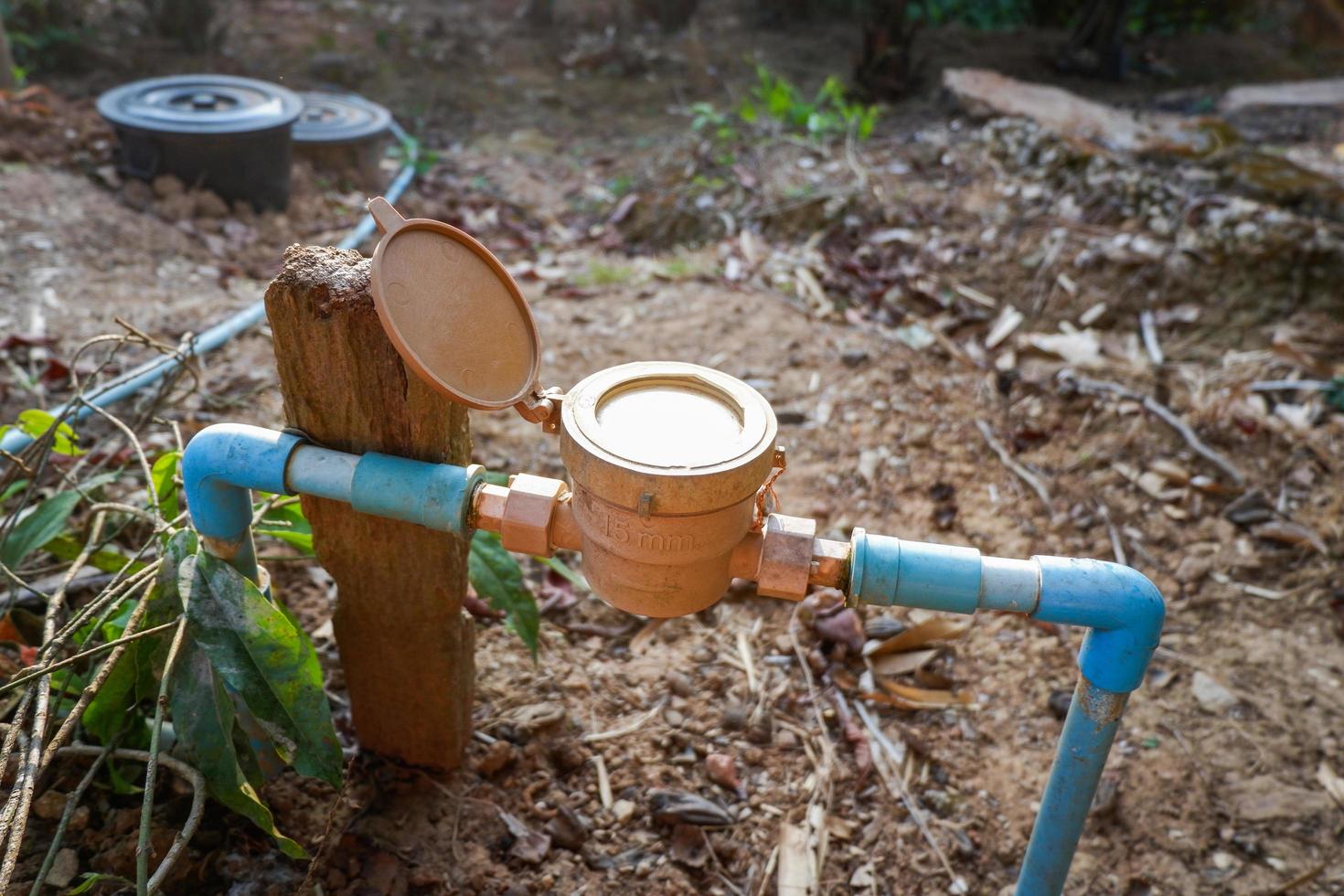 medidor de agua en tubería de agua de pvc en el suelo, medidor de agua antiguo para verificar las estimaciones de uso de agua en el hogar en el pueblo foto