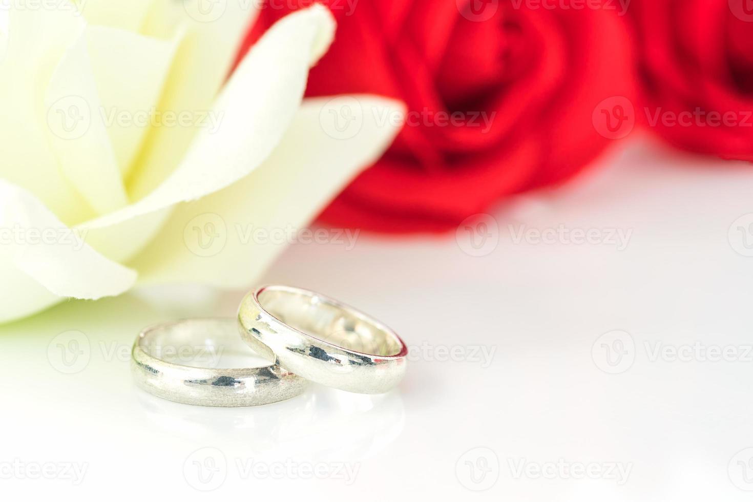 Red rose and wedding ring on white photo