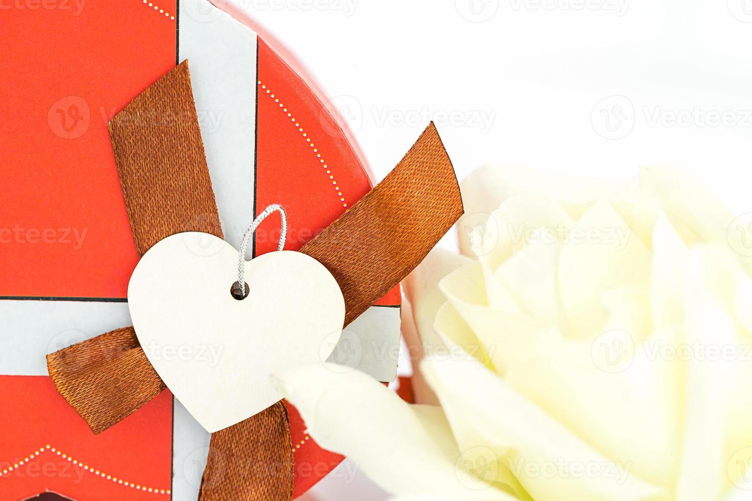 Close up white rose and heart shaped box on white photo