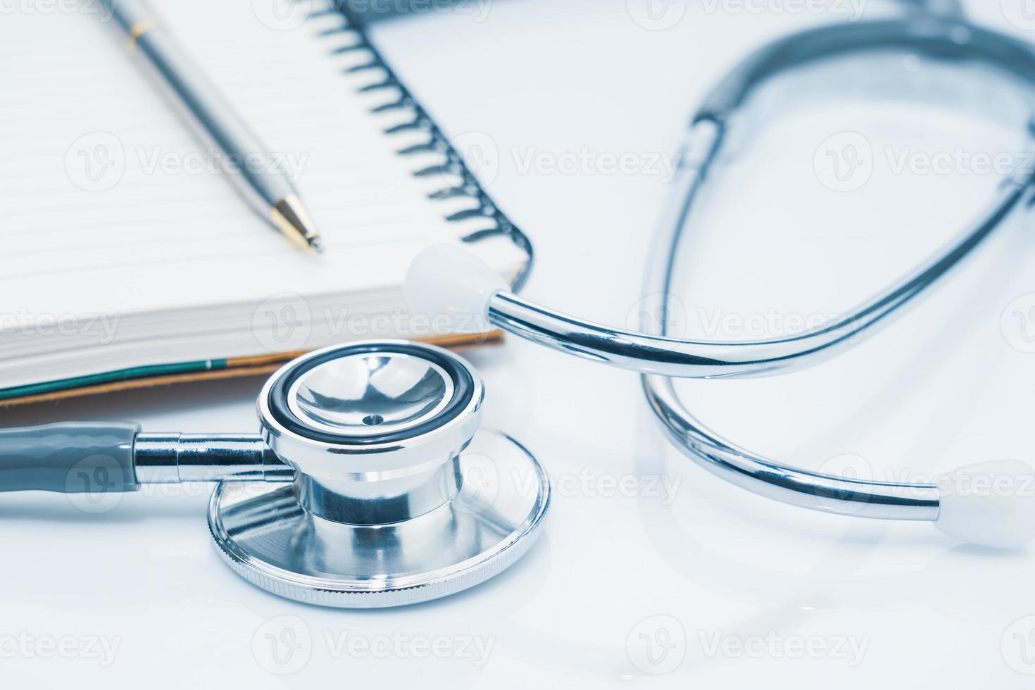 Medical stethoscope for doctor checkup and notepad on table photo